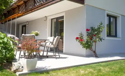 a patio of a house with chairs and a table at Apartments Korošec in Bled