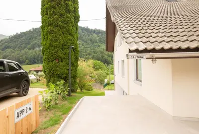 a car parked next to a house with a driveway at Apartments Korošec in Bled