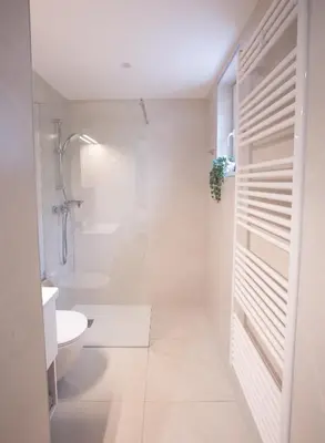 a white bathroom with a shower and a toilet at Apartments Korošec in Bled
