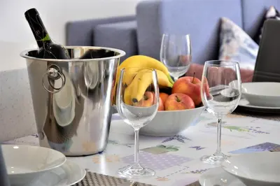 a table with two wine glasses and a bowl of fruit at Vila Ključe Apartments in Bled