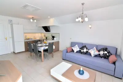 a living room with a blue couch and a kitchen at Vila Ključe Apartments in Bled