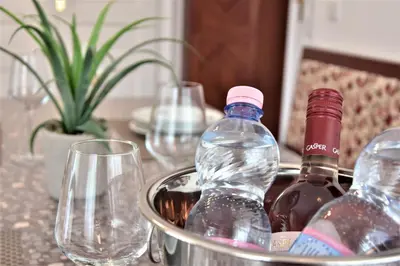 a table with wine bottles and glasses on it at Vila Ključe Apartments in Bled