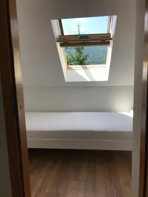 a room with a skylight and a white wall at Apartma EVA&MATIC in Kranjska Gora