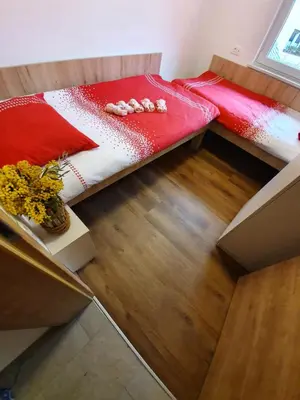 a bed with a red and white comforter in a room at Apartments Mojstrana - Kekec in Mojstrana