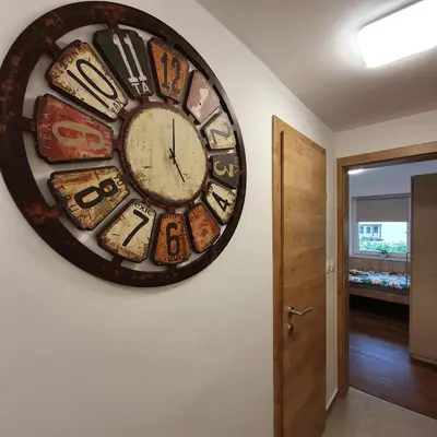 a large clock hanging on a wall in a hallway at Apartments Mojstrana - Kekec in Mojstrana