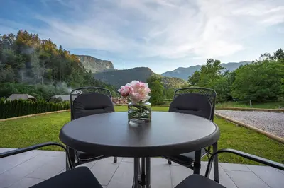 a table with chairs and a vase of flowers on it at Chilly apartment in Bled