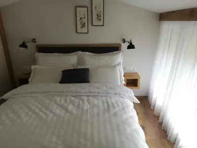 a bed with white sheets and a black pillow at Holiday House Red Deer in Preddvor