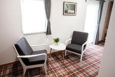two chairs and a table in a room at Hiša Poljana Rooms in Prevalje