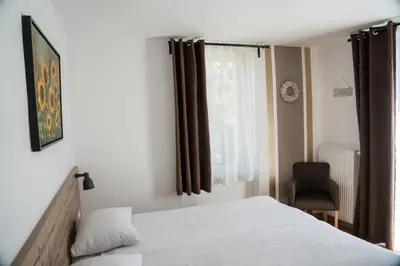 a bedroom with a bed and a window with a chair at Hiša Poljana Rooms in Prevalje