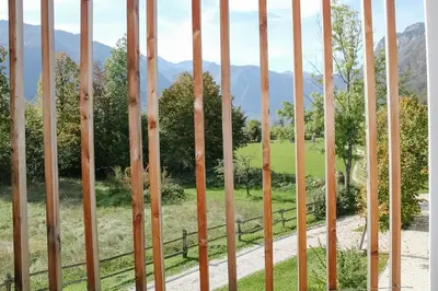 a fence with a view of a field and mountains at Residence Novak Bohinj in Bohinj