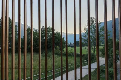 a fence with a field and mountains in the background at Residence Novak Bohinj in Bohinj