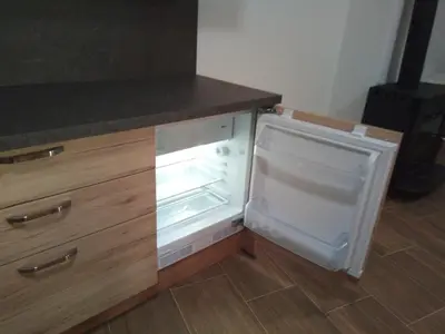 an empty refrigerator with its door open in a kitchen at APARTMAJI MATAŽIN in Črni Kal