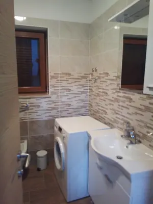 a bathroom with a sink and a washing machine at APARTMAJI MATAŽIN in Črni Kal