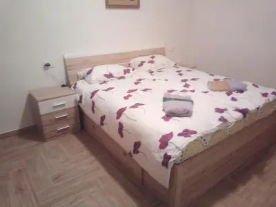 a bedroom with a bed with purple flowers on it at APARTMAJI MATAŽIN in Črni Kal