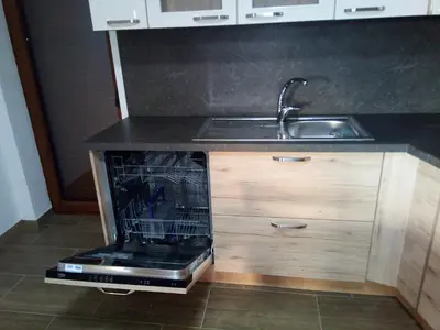 an open dishwasher in a kitchen next to a sink at APARTMAJI MATAŽIN in Črni Kal