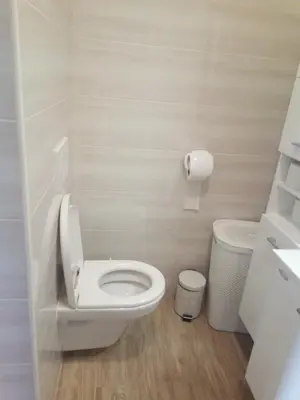 a bathroom with a toilet and a trash can at APARTMAJI MATAŽIN in Črni Kal