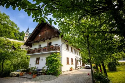a large white building with a wooden roof at Sobe Odar Andrej in Bohinj