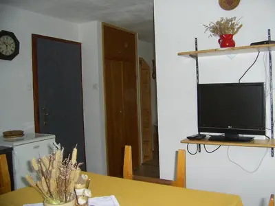 a room with a table with a television on a shelf at Sobe Odar Andrej in Bohinj