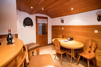 a dining room with a wooden table and chairs at Sobe Odar Andrej in Bohinj