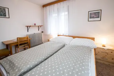a bedroom with a large bed with a desk and a window at Sobe Odar Andrej in Bohinj