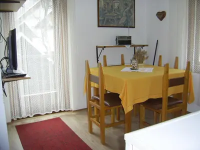 a dining room with a yellow table and chairs at Sobe Odar Andrej in Bohinj