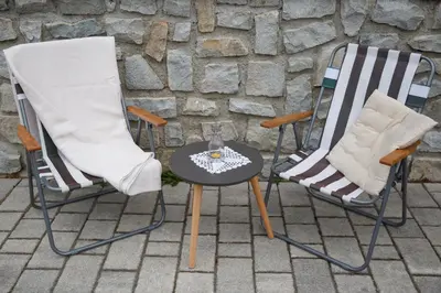 two chairs and a table on a patio at Apartma Natura Kope in Šmartno pri Slovenj Gradcu