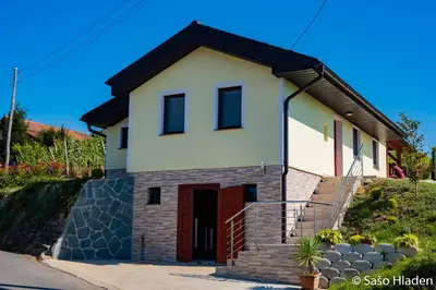 a small white house with a red door at Vinska klet Seršen in Dobrovnik