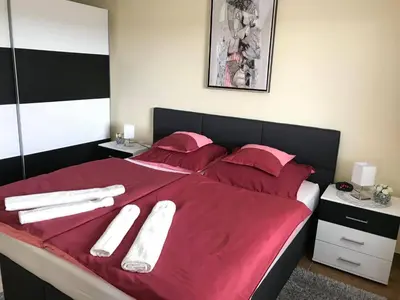 a bed with red sheets and white towels on it at Vinska klet Seršen in Dobrovnik