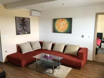 a living room with a red couch and a table at Vinska klet Seršen in Dobrovnik