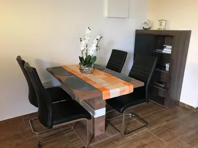 a dining room table with black chairs and a table with flowers on it at Vinska klet Seršen in Dobrovnik