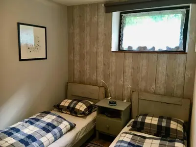 two twin beds in a room with a window at Hisa Smast in Kobarid