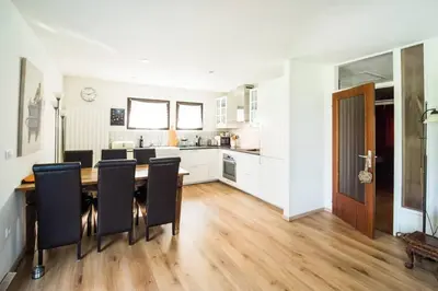 a kitchen and dining room with a table and chairs at Hisa Smast in Kobarid