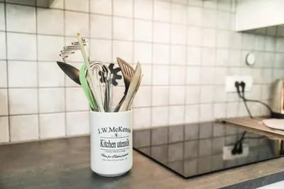 a white vase filled with utensils on a kitchen counter at Hisa Smast in Kobarid