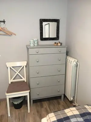 a bedroom with a dresser and a chair and a mirror at Hisa Smast in Kobarid