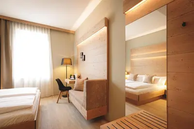 a hotel room with two beds and a desk at Boutique Hotel Sunrose 7 - Gourmet & SPA in Bohinj