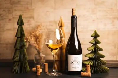 a bottle of wine next to a glass of wine at Boutique Hotel Sunrose 7 - Gourmet & SPA in Bohinj