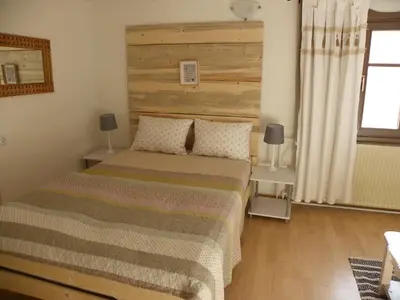 a bedroom with a bed with a wooden headboard at InGreen house in Bohinjska Bela