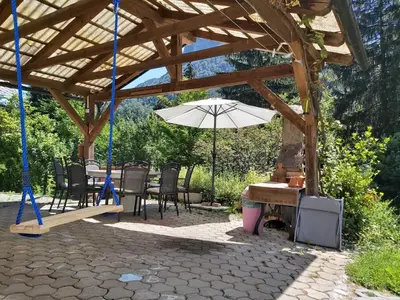 a wooden pavilion with a table and an umbrella at InGreen house in Bohinjska Bela