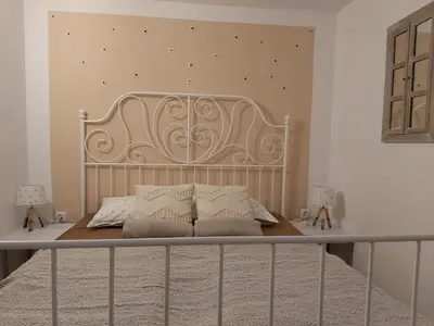 a bedroom with a bed with a metal headboard at InGreen house in Bohinjska Bela