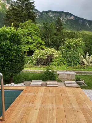 a wooden table with a view of a garden at InGreen house in Bohinjska Bela
