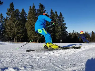 a person in a blue snowsuit skiing in the snow at Apartmaji Mara in Ribnica na Pohorju