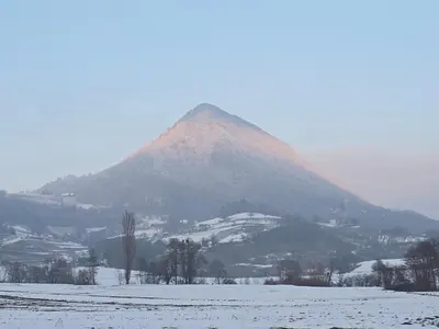 a mountain in the distance with a snow covered field at Relaxing Cottage Donacka Gora in Rogatec