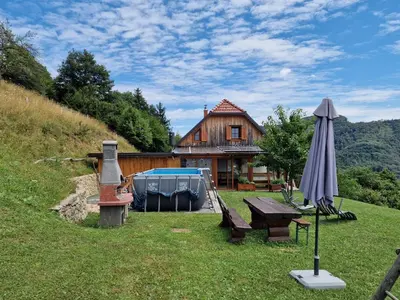a house with a picnic table and an umbrella at Vacation House Donacka Gora in Rogatec