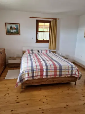 a bedroom with a bed with a striped comforter and a window at Vacation House Donacka Gora in Rogatec