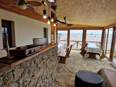 a living room with a stone wall and a table at Vacation House Donacka Gora in Rogatec
