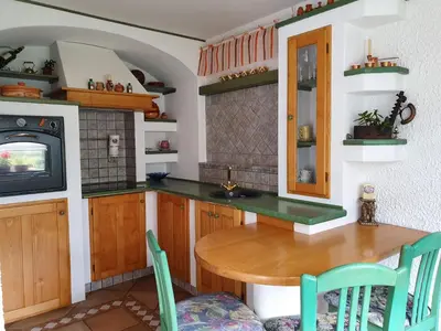 a kitchen with a wooden table and a tv at Apartma MAELL 1 in Most na Soči