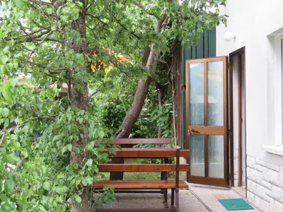 a wooden bench sitting next to a tree at Apartma Jager in Bovec