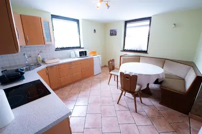 a kitchen with a table and a table and chairs at APARTMA JAKOPIČ in Zgornje Gorje