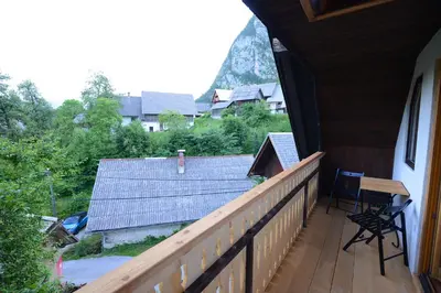 a balcony of a house with a table and chairs at Apartmaji Pekovec Bohinj in Bohinj