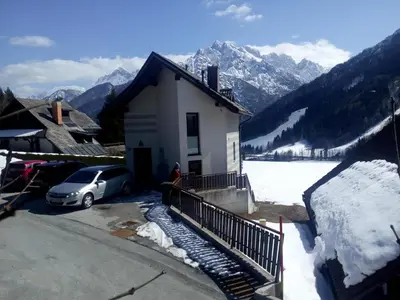 a car parked in front of a house in the snow at JULIJA 3 SUNNY APPARTMENT in Kranjska Gora
